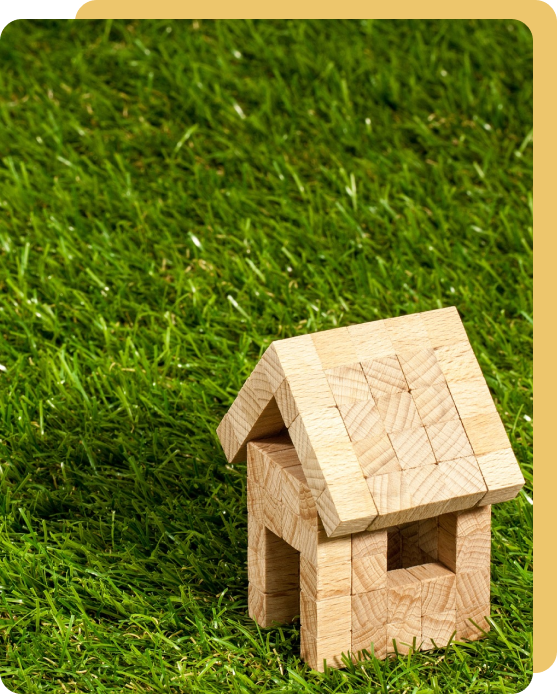 A wooden toy house sitting in the grass.